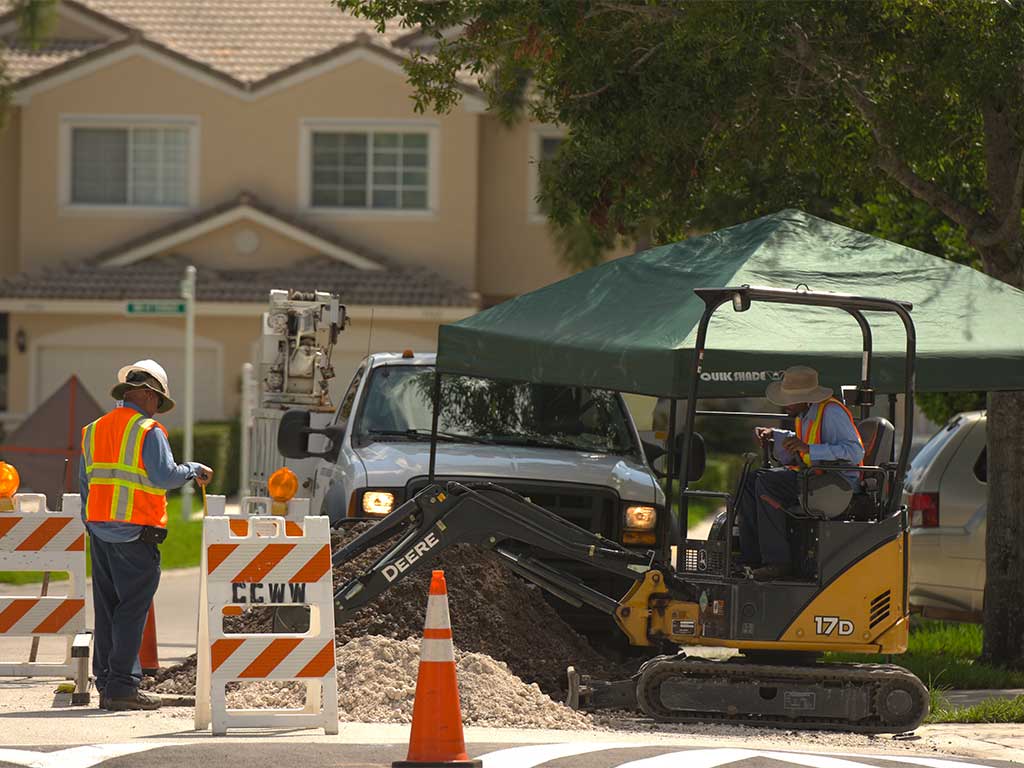 City workers using mini excavator to dig